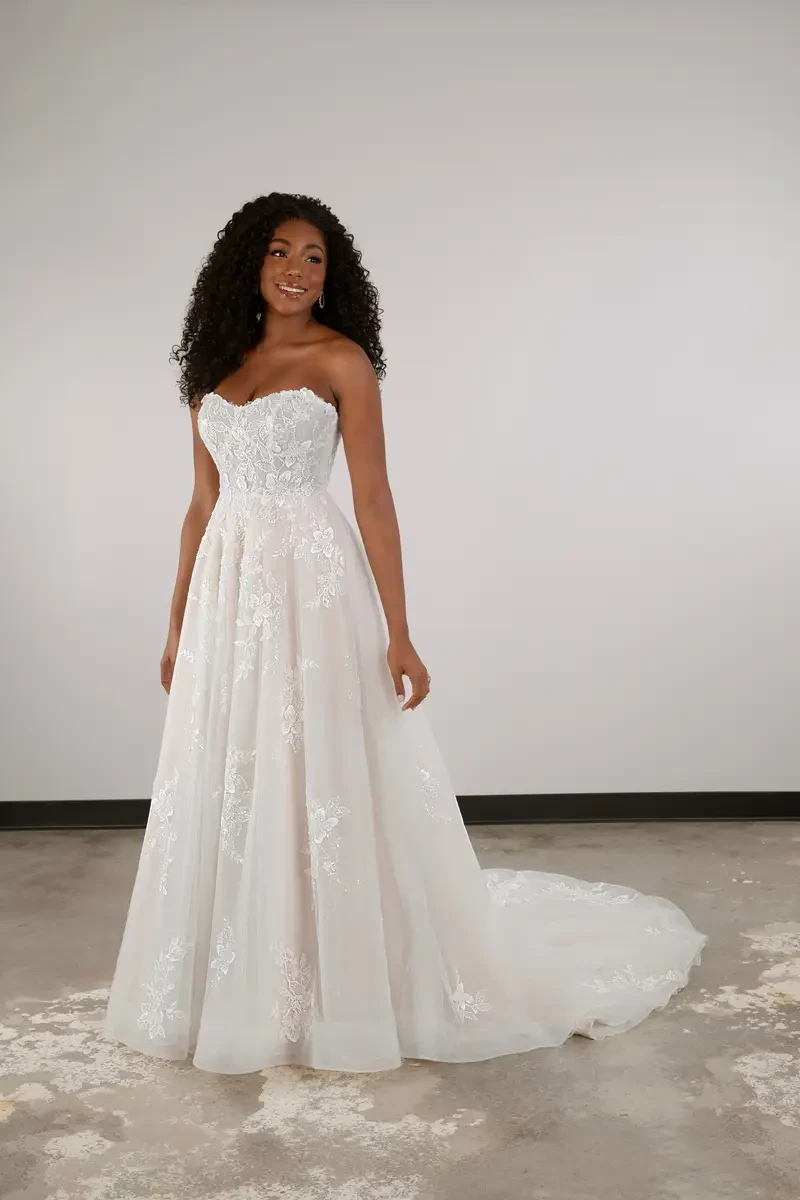 model is wearing a strapless a-line plus size wedding dress