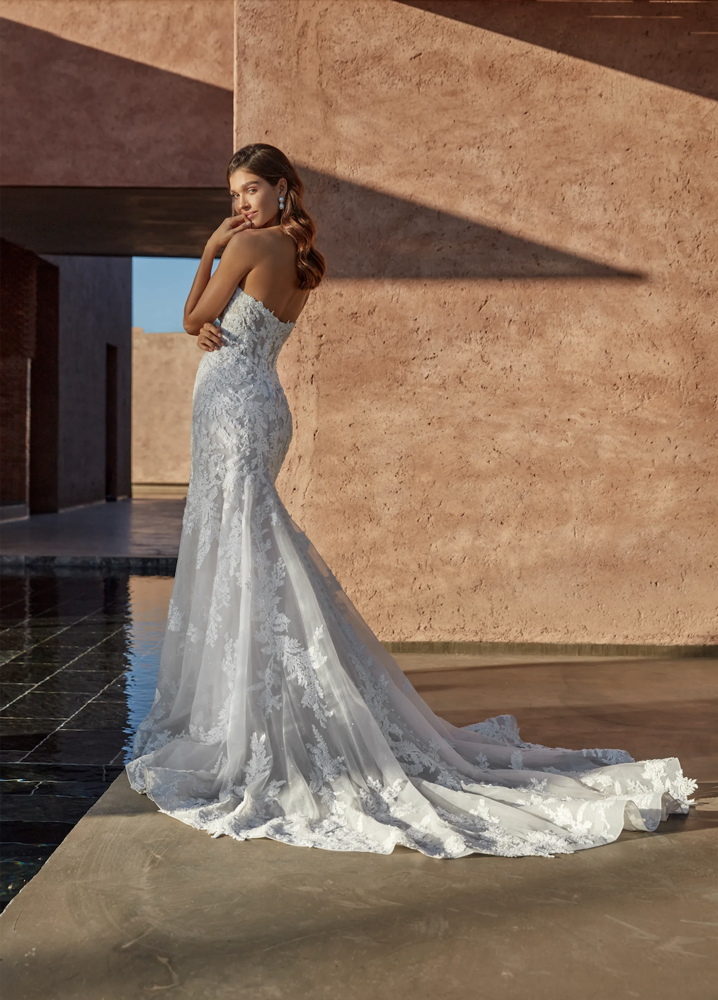 model is wearing a strapless lace bridal gown