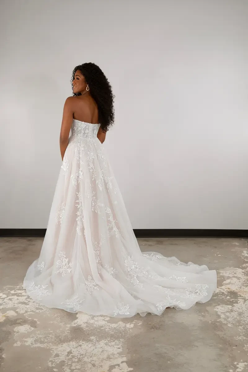 model is wearing a strapless a-line plus size wedding dress
