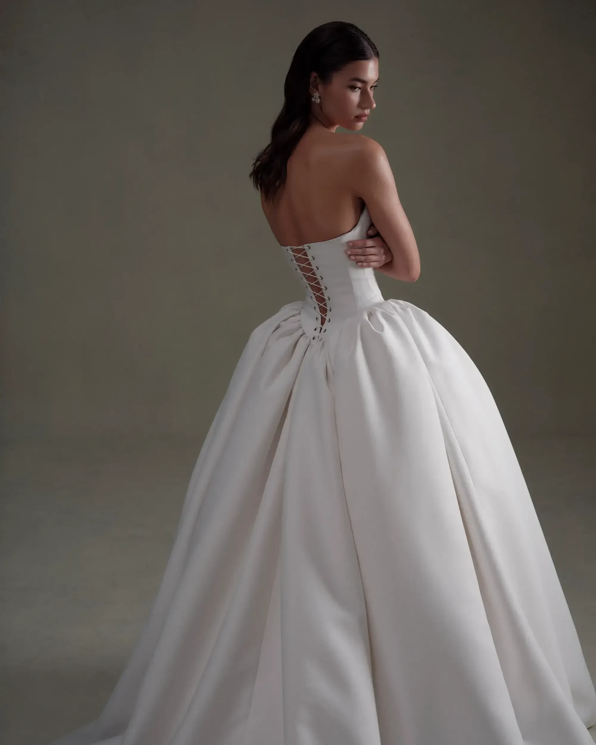model is wearing a strapless basque waist ball gown wedding dress