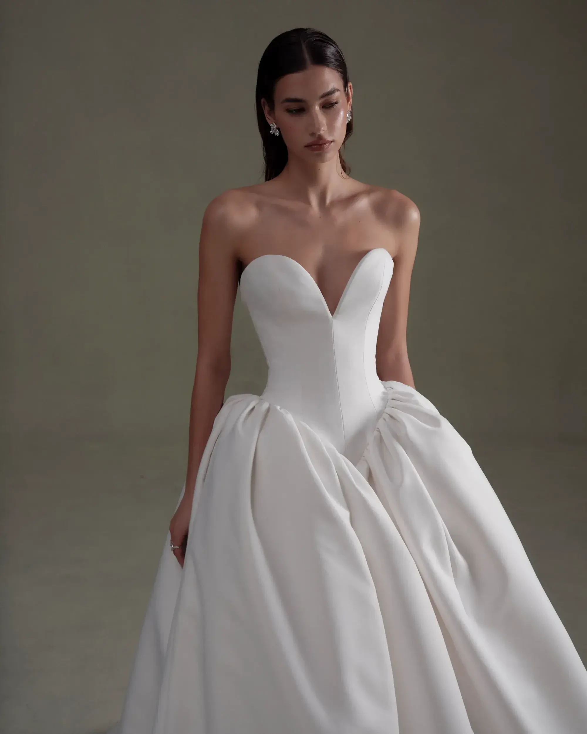 model is wearing a strapless basque waist ball gown wedding dress